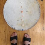 Terra cotta platter by Berkeley ceramicist Nancy Selvin, with small shards from famous pottery makers, including Selvin, which Barbara Falconer Newhall purchased. Feet are Newhall's. Photo by Barbara Newhall