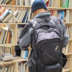 A man with a back pack browses for book at the Bay Area Book Festival. Photo by Barbara Newhall