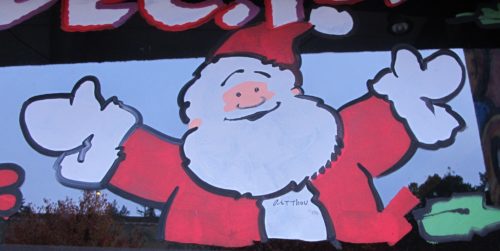 A cheery Santa Claus painted by Art Thou on a store window in Oakland, CA, 2016. Christmas is bigger than Christianity. Photo by Barbara Newhall
