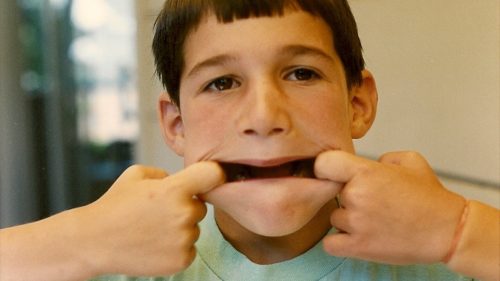 A 7-year-old boy makes a yucky  face by stretching his mouth wide. Photo by Barbara Newhall