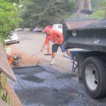 asphalt crew at work filling in gutter in front of my house. Photo by Barbara Newhall