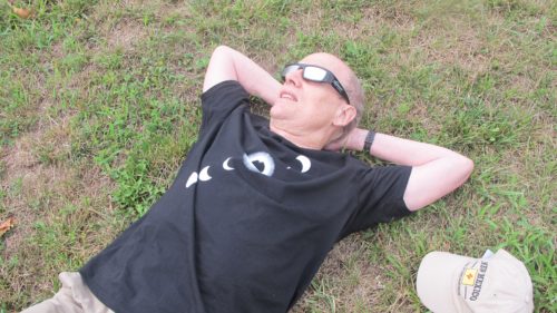 A totality disappointment: An eclipse chaser lies on the ground for a better view of the total eclipse August, 2017, St. Joseph, MO. Photo by Barbara Newhall