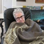 Elderly woman with mono. Author and blogger Barbara Falconer Newhall succumbs to mono and curls up with an alpaca blanket for comfort. Photo by Jon Newhall