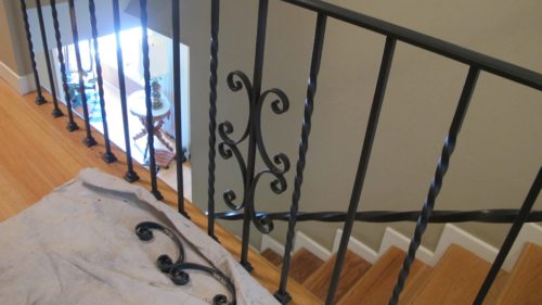 over-wrought iron curlicues on a staircase railing