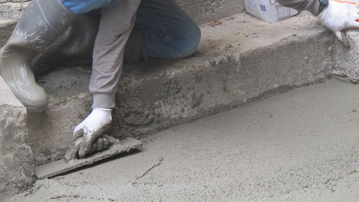 working with their hands -- troweling-concrete